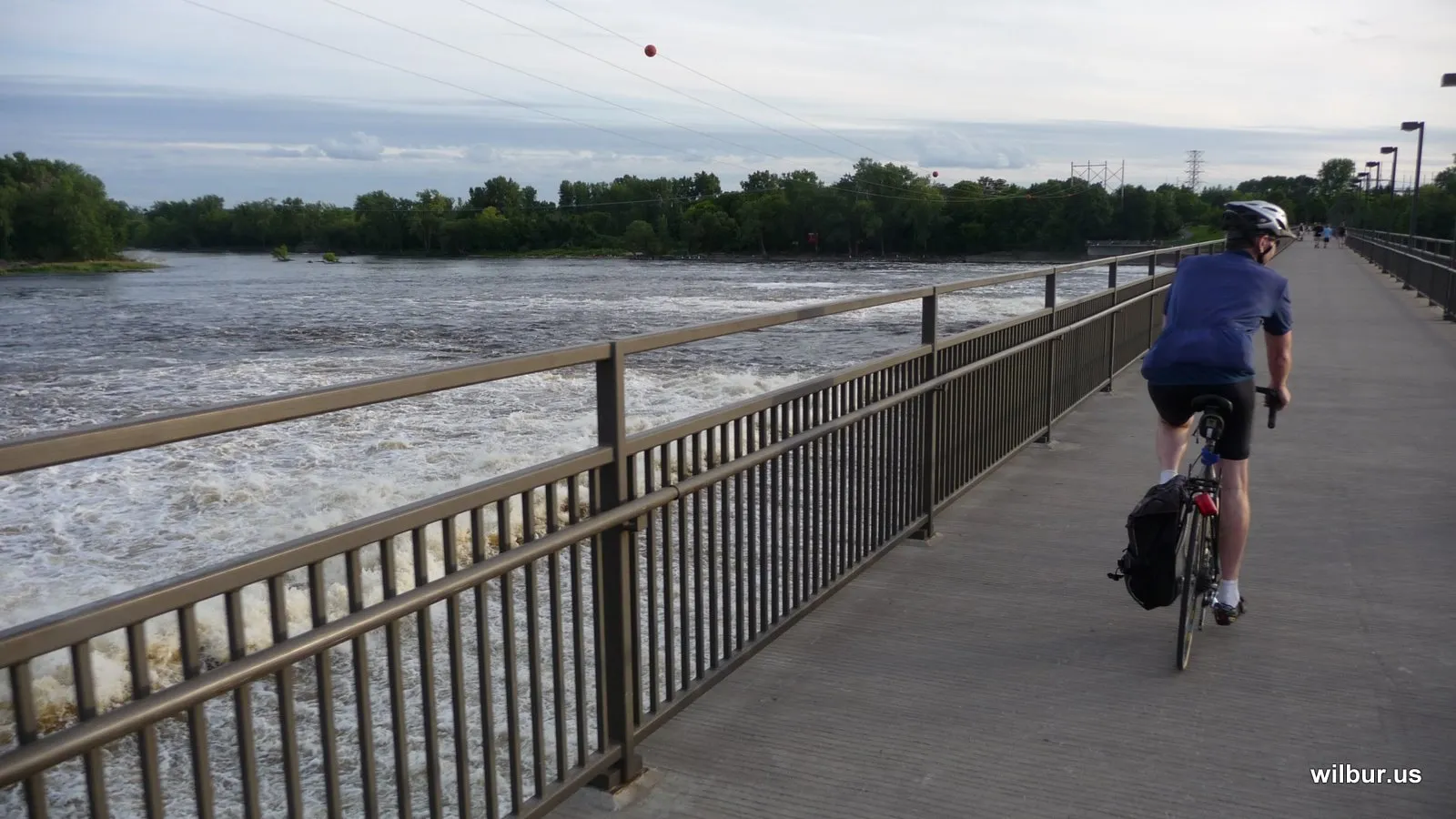 A cyclist crossing the Coon Rapids Dam walkway over the Mississippi River