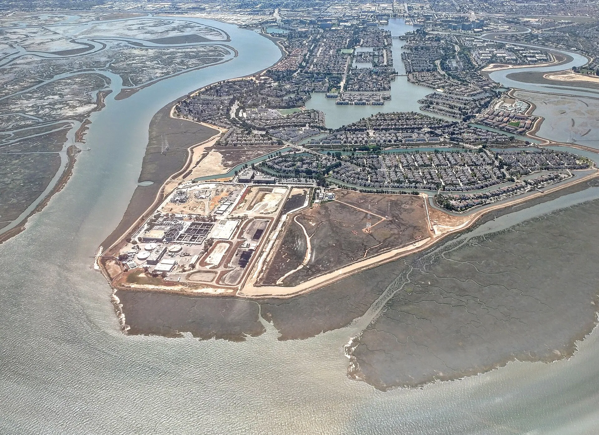 Aerial view of a water treatment plant beside a bay
