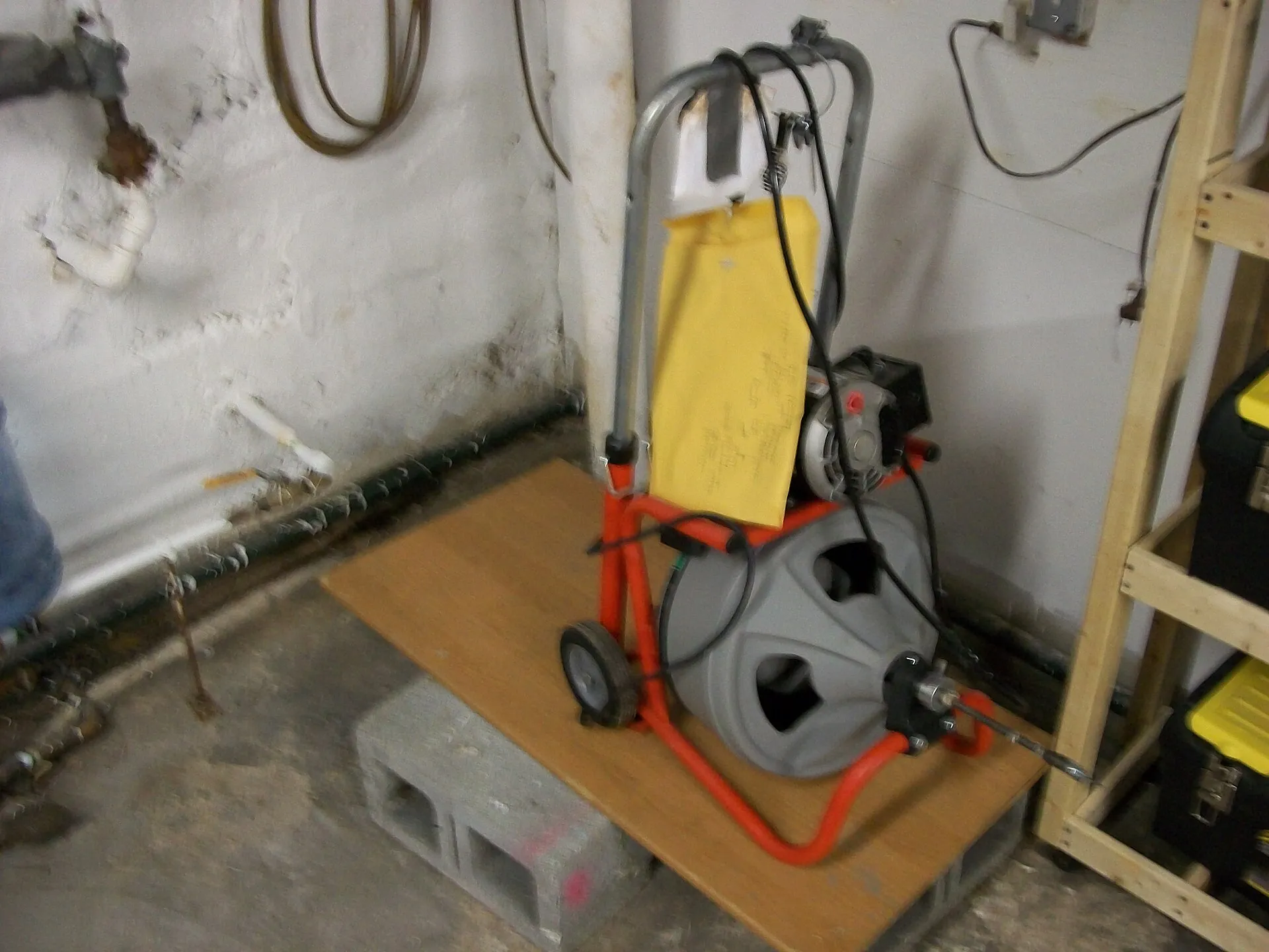 A powered drain-cleaning machine in a basement