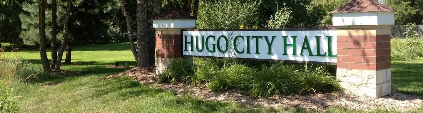 The Hugo City Hall sign among trees